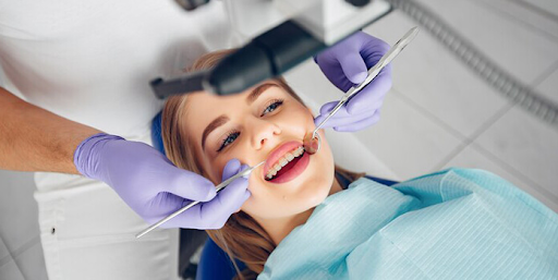 Dentist performing teeth cleaning with scaler and mirror 